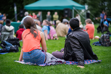 Friends enjoying an outdoors music community event, festival.