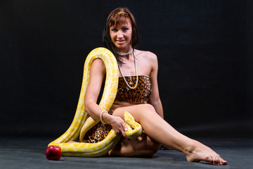 Woman with a snake eating red apple