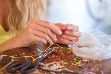 Woman making bracelet with colorful beads