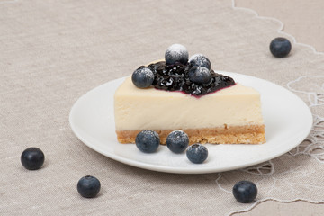 Cheese Cake With Blueberry Jam And Blueberries On White Plate