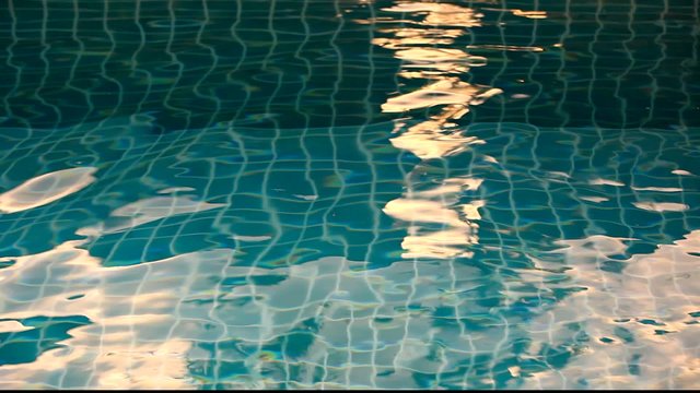 Shining blue water ripple in pool at sunset time. Video shift