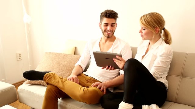 Young couple with a Tablet PC on the Sofa