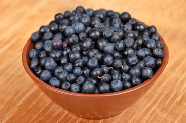 Blueberry in bowl on vintage wooden background