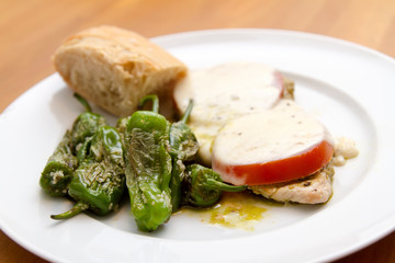 Beef cutlet with mozzarella, tomatoes and pimientos de padrón