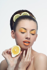 Young woman with oranges and makeup