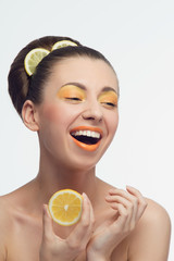 Young woman with oranges and makeup