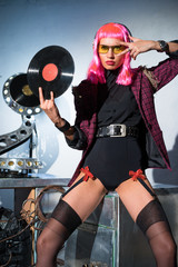 Fototapeta na wymiar DJ girl in pink wig with plate in hand