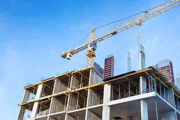 Construction site with cranes against blue sky