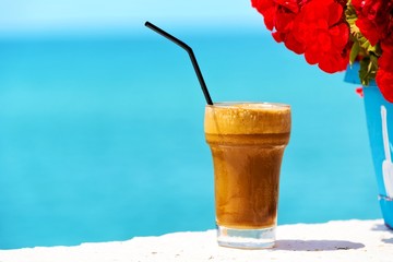 Ice coffee against sea background.