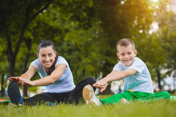 son and mother are doing exercises in the park