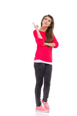 Fototapeta premium Young woman pointing up at empty space.