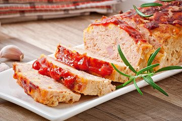 Homemade ground meatloaf with ketchup and rosemary