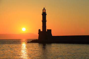 Fototapeta na wymiar Sunset at harbor with lighthouse Chania Crete