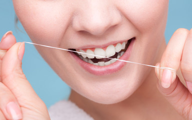 Girl cleaning teeth with dental floss. Health care