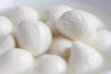Foto auf Glas Small white mozzarella balls in a white dish with liquid. © Moving Moment