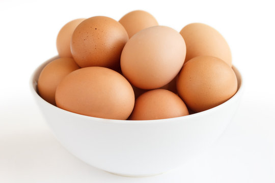 Large white bowl bowl af chicken eggs on white