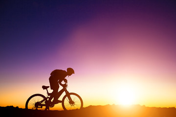 Fototapeta na wymiar mountain bicycle rider on the hill with sunrise background