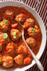 meatballs with tomato sauce in pan with spoon