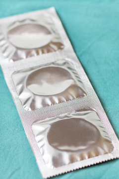 Three condoms on blue background