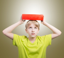 Preteen boy with a book on his head