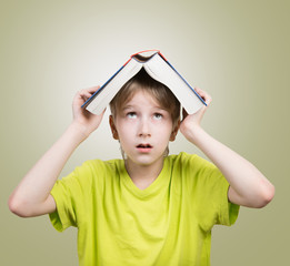 Preteen boy with a book on his head