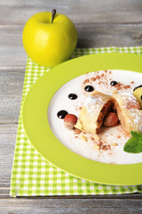 Tasty homemade apple strudel with nuts, mint leaves and