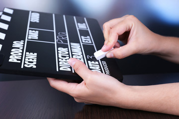Black cinema clapper board in hands, close up