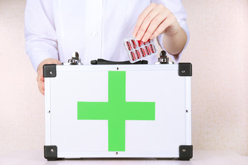 Nurse holding first aid kit, close up