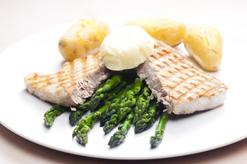 tuna steak with green asparagus and unpeeled potatoes