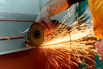 auto mechanic grinding metal on a metal surface