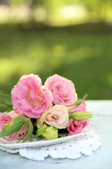 Eustoma flowers on color wooden table, outdoors