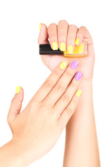 Female hand with stylish colorful nails holding bottle with