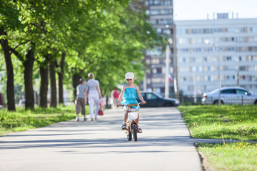 Girl riding bicycle in park at summer day