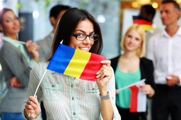 Happy businesswoman holding flag of Romania