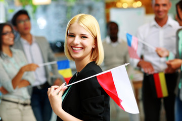 Cheerful businesswoman holding flag of Poland 