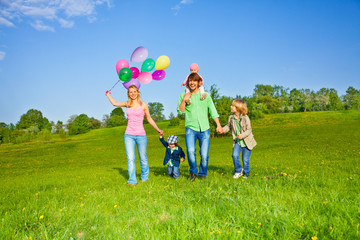 Happy family walks with balloons in park