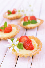 Tasty tartlets with strawberries on table close-up