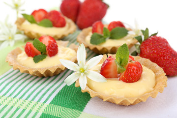 Tasty tartlets with strawberries on table close-up