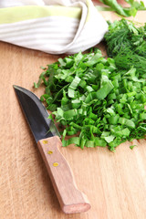 Chopped greens with knife on cutting board