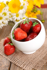 Ripe sweet strawberries in bowl on table close-up