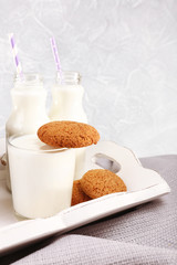 Milk and cookies on table on light grey background