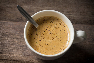 Creamy coffee on wood table.