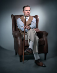 Retro classic business fashion man sitting in big leather chair.