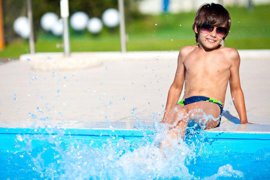 Мальчик у бассейна в солнечных очках