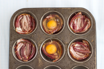 Obraz na płótnie Canvas Raw Bacon and Eggs in a muffin pan