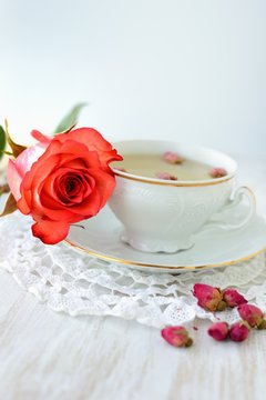 Cup of tea with dried roses and fresh rose