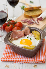 Spanish traditional dish fried eggs with serrano ham and potatoe