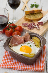 Spanish traditional dish fried eggs with serrano ham and potatoe