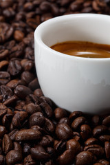 A cup of coffee with coffee bean as background