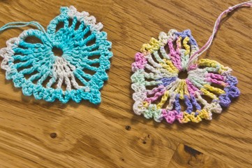 Crochet two hearts on a wooden table